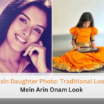Asin Daughter Photo showing Arin Rayn in traditional orange South Indian attire making floral rangoli for Onam.